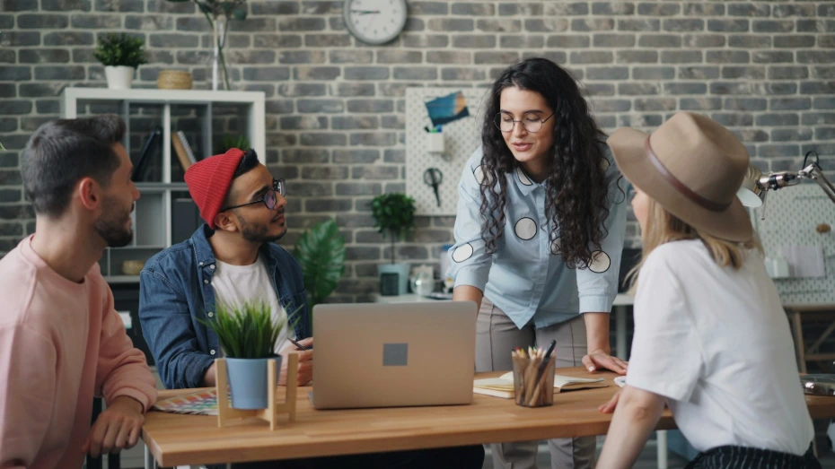 a group of people sitting around a wooden table